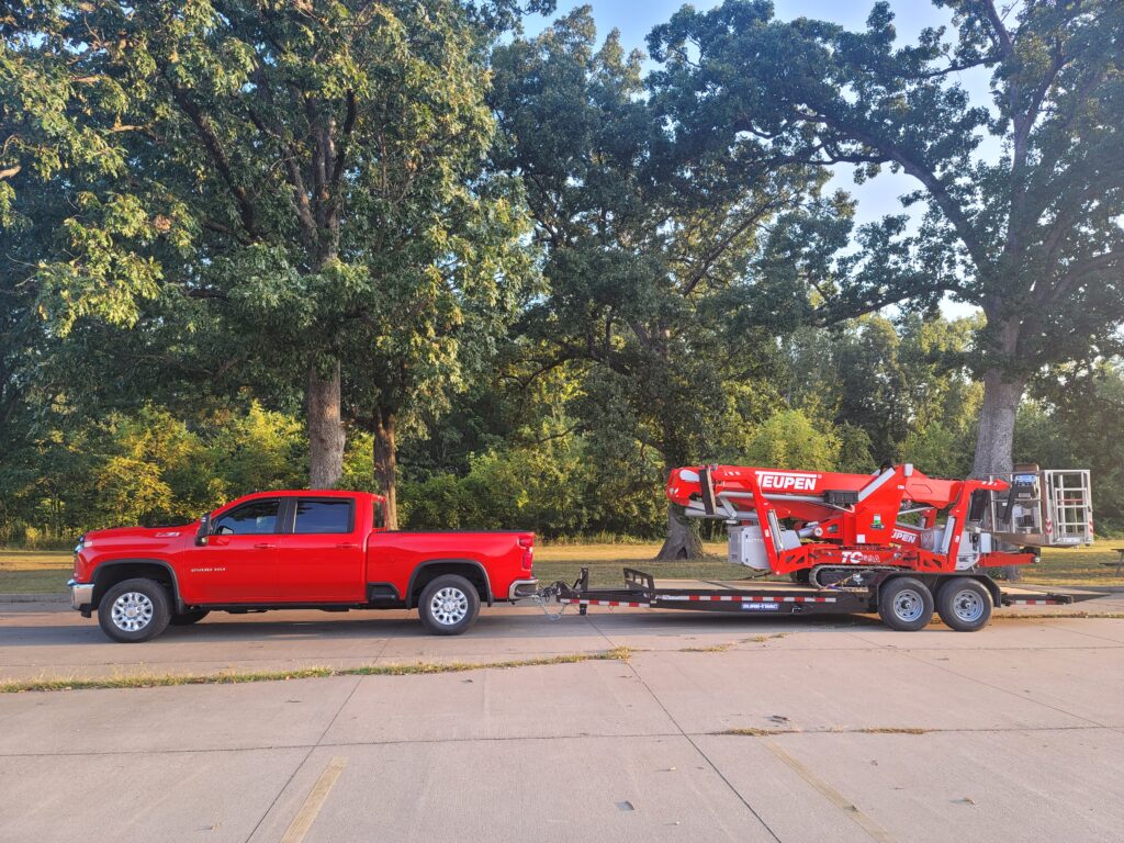A red truck with a crane attached to it.